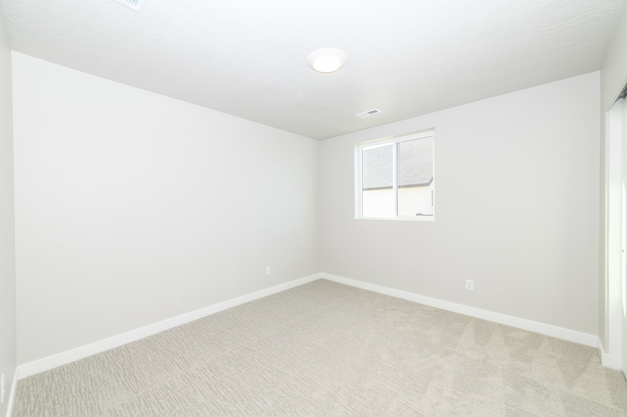 Spare room featuring light carpet and baseboards