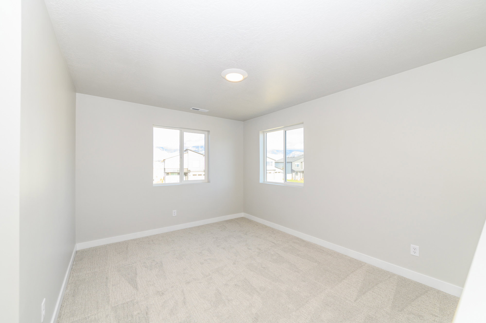 Spare room with light carpet and baseboards