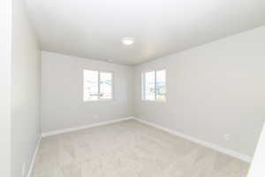 Spare room with light carpet and baseboards