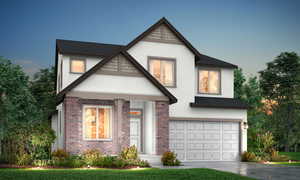 View of front of home with stucco siding, a garage, driveway, and brick siding