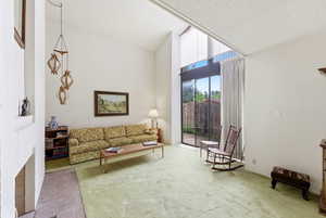 Living area with carpet floors and vaulted ceiling