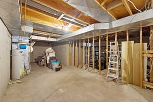 Unfinished below grade area featuring gas water heater and heating unit