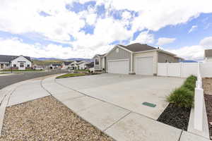View of front of property with a garage, concrete driveway, a residential view, board and batten siding, and a mountain view