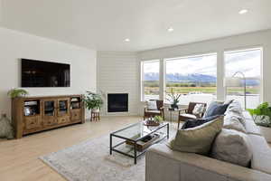Living area with light wood-style floors, recessed lighting, a mountain view, and a large fireplace