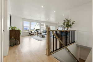 Corridor featuring an upstairs landing, healthy amount of natural light, recessed lighting, and light wood-type flooring