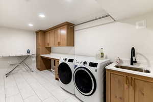 Laundry area featuring washer and dryer, recessed lighting, and cabinet space