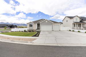 View of front facade featuring board and batten siding, a garage, concrete driveway, a mountain view, and roof with shingles