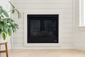 Detailed view of a glass covered fireplace and wood finished floors