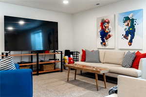 Living area with light carpet and recessed lighting