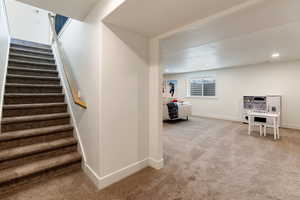 Stairs with carpet flooring and recessed lighting