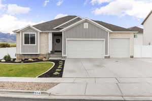 Ranch-style home with stone siding, board and batten siding, a garage, roof with shingles, and driveway