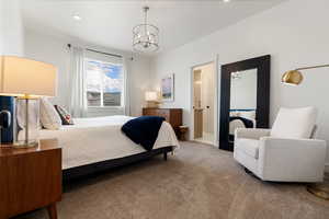 Carpeted bedroom with a chandelier and ensuite bath