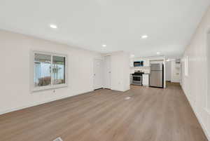 Unfurnished living room with light wood-style flooring and recessed lighting