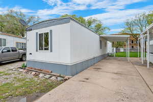 View of property exterior featuring an attached carport and driveway