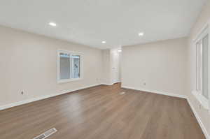 Spare room featuring light wood finished floors and recessed lighting