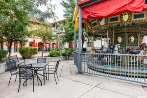 View of patio featuring outdoor dining space and merry-go-round
