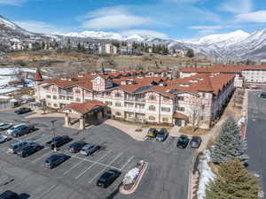 Snowy aerial view with a mountain view and a view of the complex