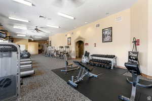 Gym with ceiling fan and a textured ceiling