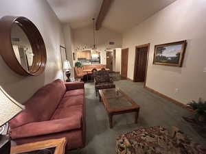 Carpeted living area with vaulted ceiling