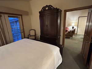 Bedroom with access to outside and dark carpet