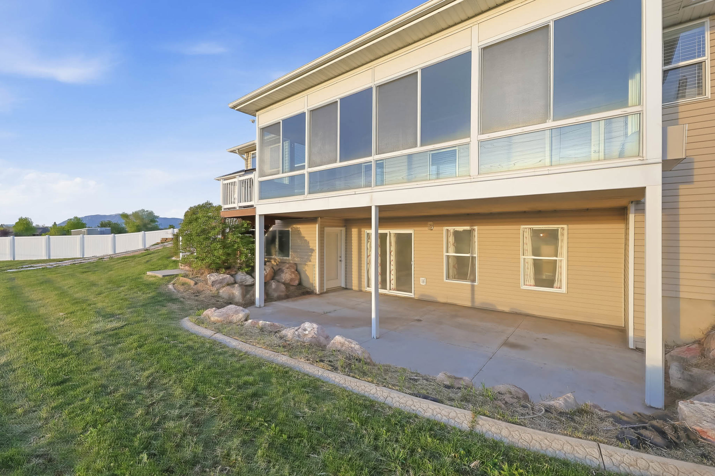 Back of house with a patio area, a sunroom, and a mountain view