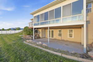 Back of house with a patio area, a sunroom, and a mountain view