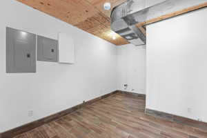 Basement featuring electric panel and wood tiled floors, plumbing for sink
