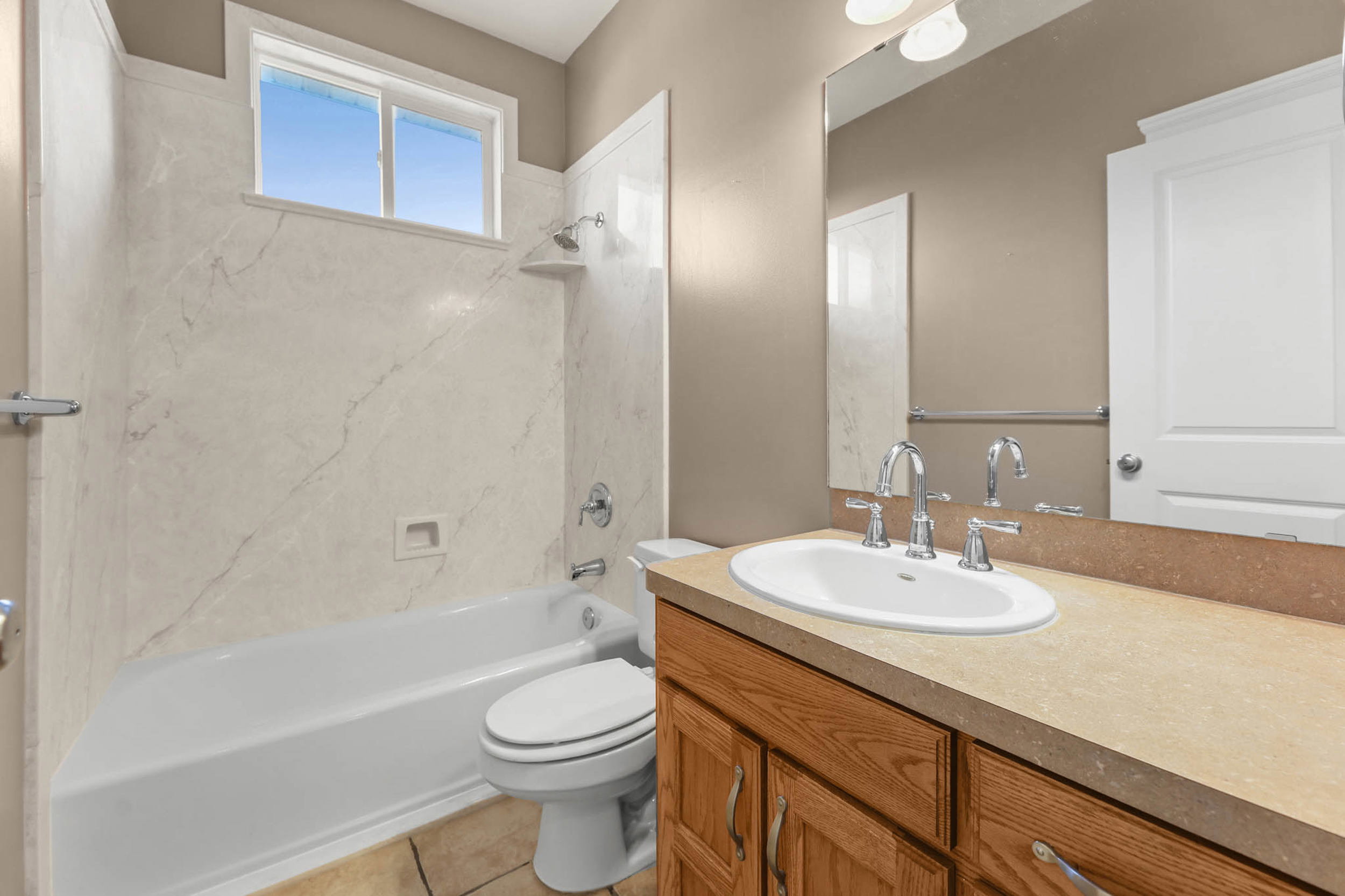 Full bath featuring vanity, shower / bath combination, and light tile patterned floors