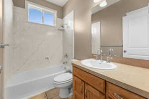 Full bath featuring vanity, shower / bath combination, and light tile patterned floors