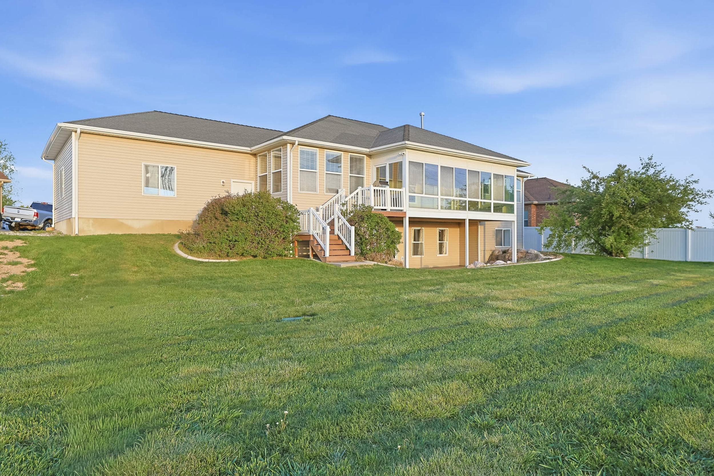 Rear view of property with a sunroom and a lawn