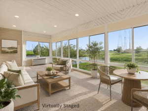 Sunroom featuring extensive window-panes, wood-finish paneling, recessed lighting, and textured carpeting Virtually Staged