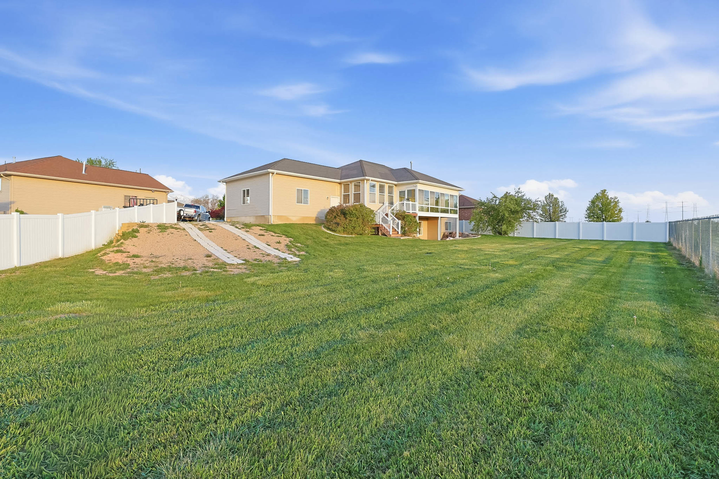 Rear view of house with a fenced backyard and a deck