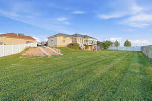 Rear view of house with a fenced backyard and a deck