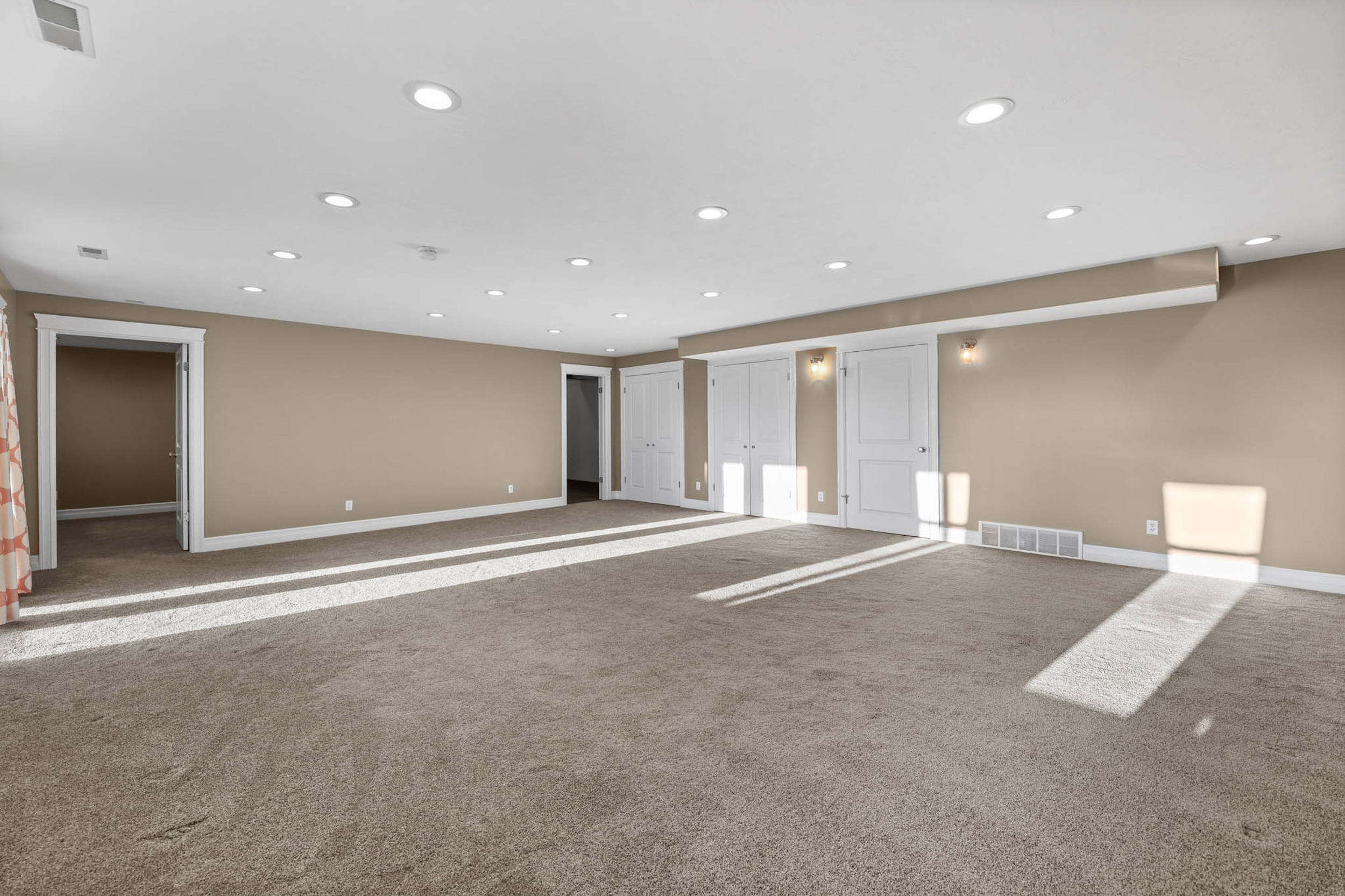 Carpeted empty room with baseboards and recessed lighting