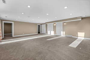 Carpeted empty room with baseboards and recessed lighting