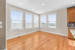 Unfurnished dining area with light wood-style flooring and recessed lighting