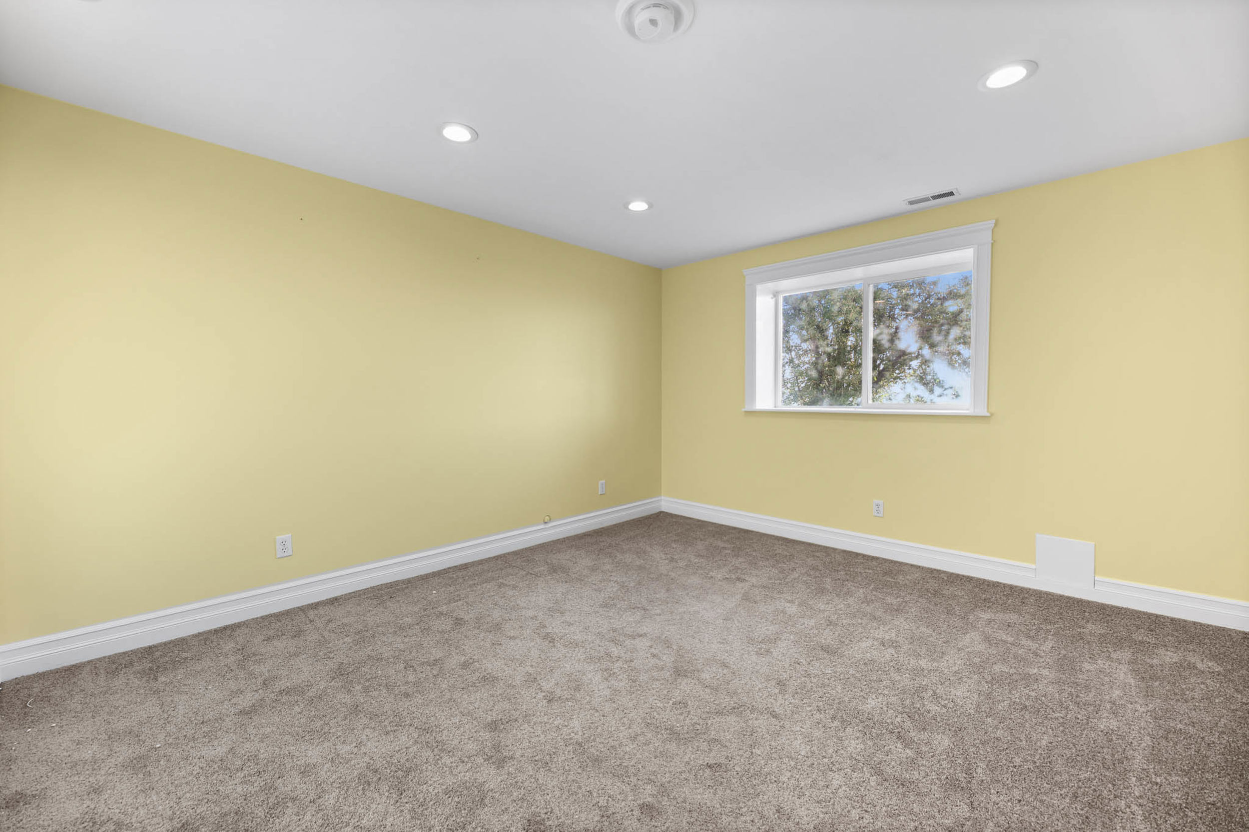 Carpeted spare room with baseboards and recessed lighting