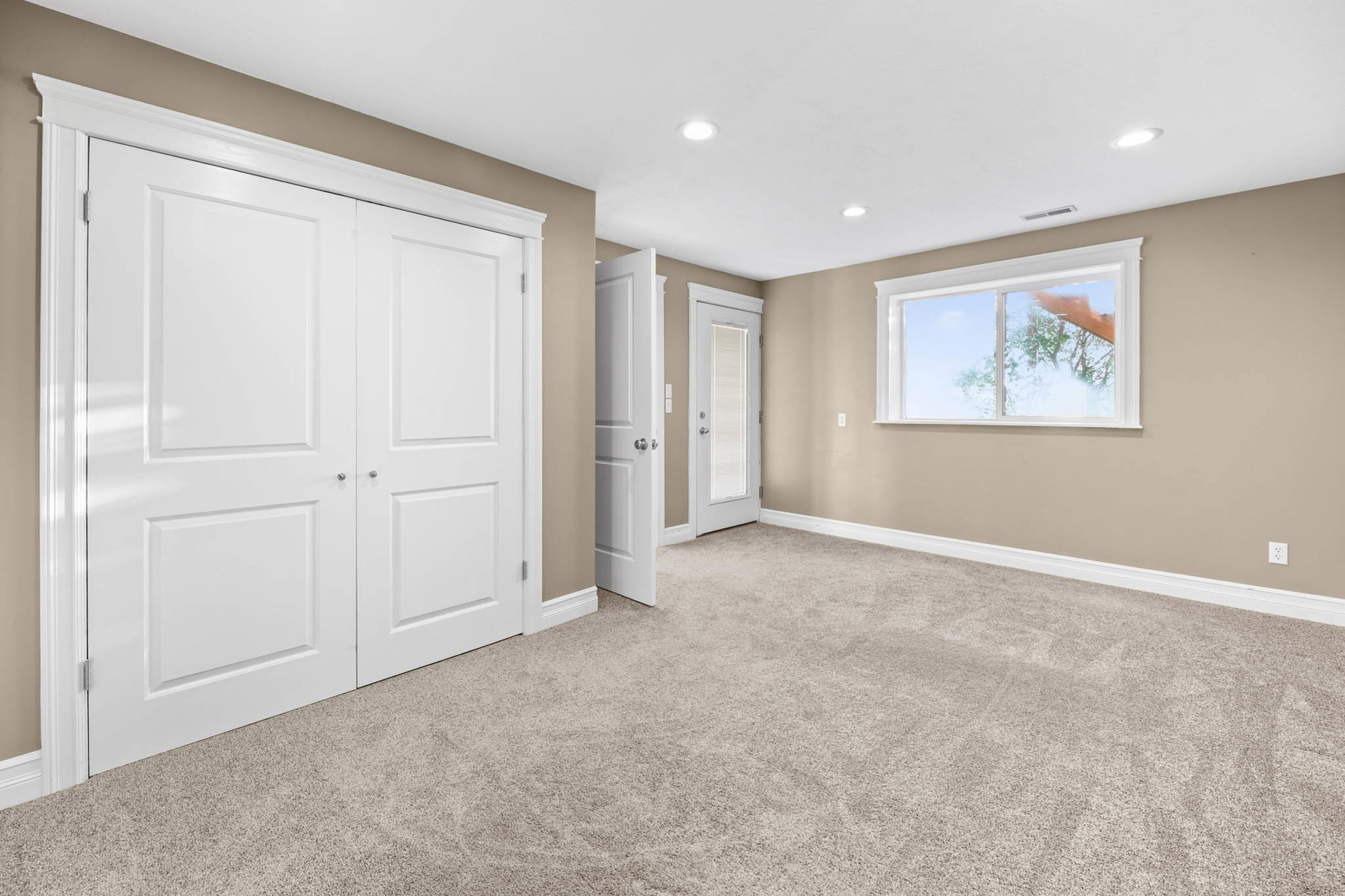 Unfurnished bedroom featuring light colored carpet, a closet, and recessed lighting. external access