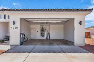 Garage featuring driveway and strapped water heater