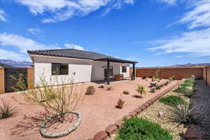 Rear view of property with a mountain view, a patio, a fenced backyard, and stucco siding