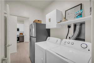 Laundry room featuring washing machine and dryer and cabinet space