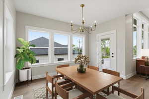 Dining room with suspended lighting and light wood-type flooring