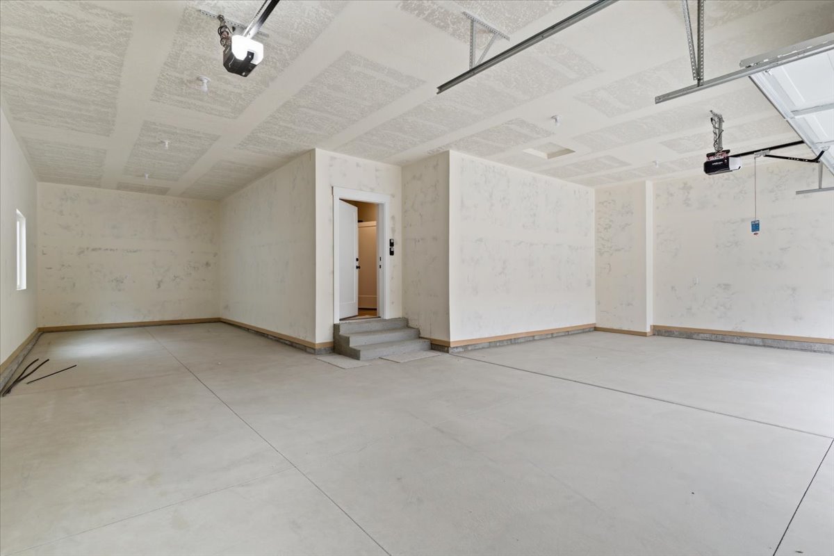 Garage featuring baseboards and a garage door opener