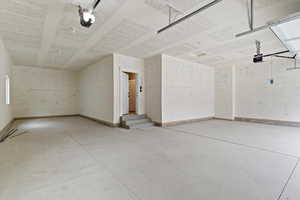 Garage featuring baseboards and a garage door opener