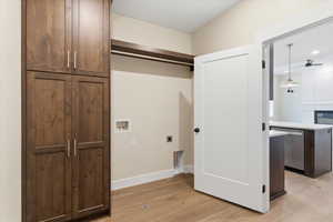 Laundry area with light wood-style flooring, electric dryer hookup, hookup for a washing machine