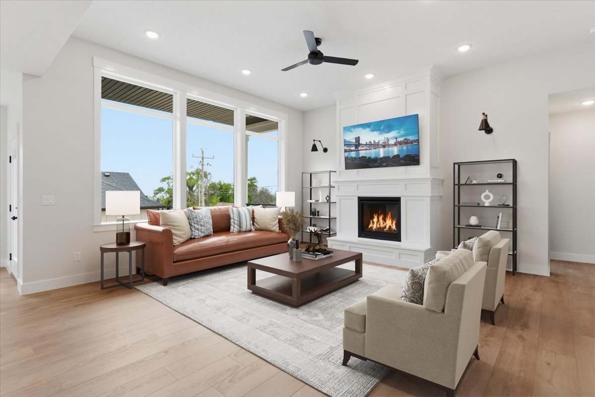 Living area with a large fireplace, a ceiling fan, light wood-style floors, and recessed lighting