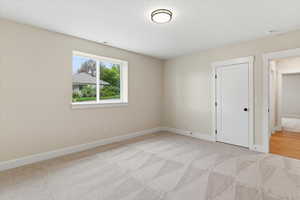 Unfurnished room featuring light colored carpet and baseboards