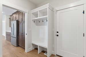 Mudroom with light wood-style floors and baseboards