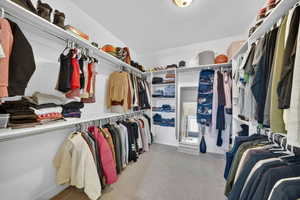 Walk in closet featuring light colored carpet