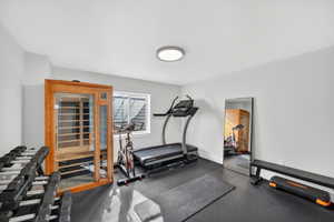 Workout area with dark flooring and a sauna